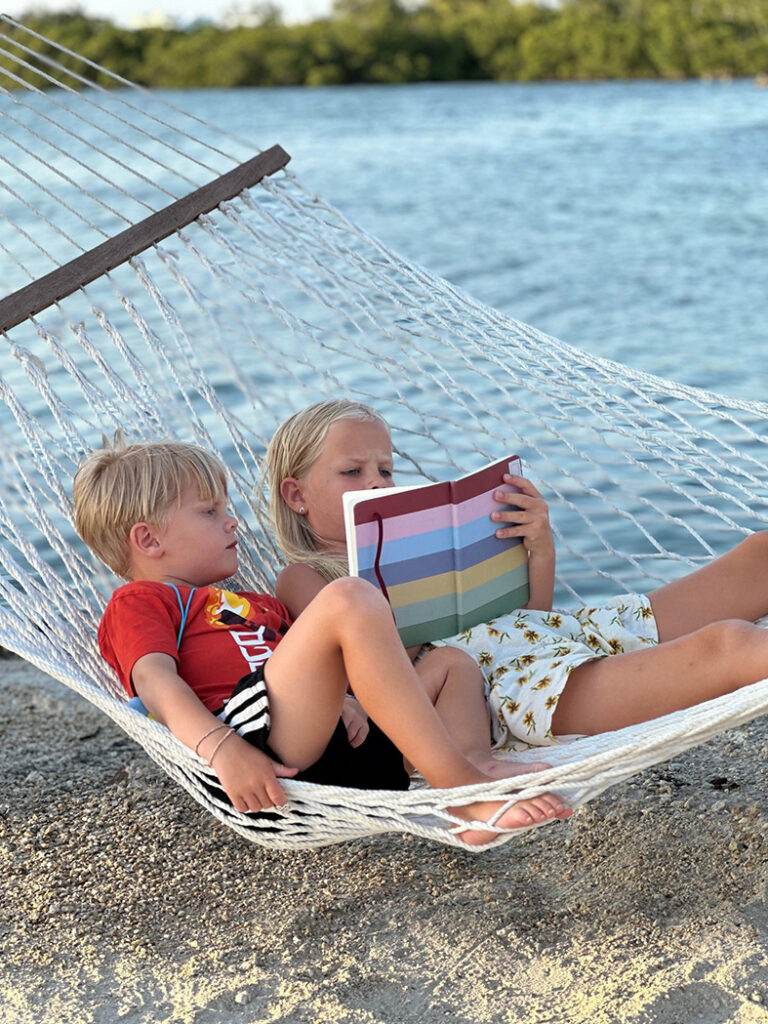 Anker og Rosa læser i en bog i hængekøje på en strand i Florida