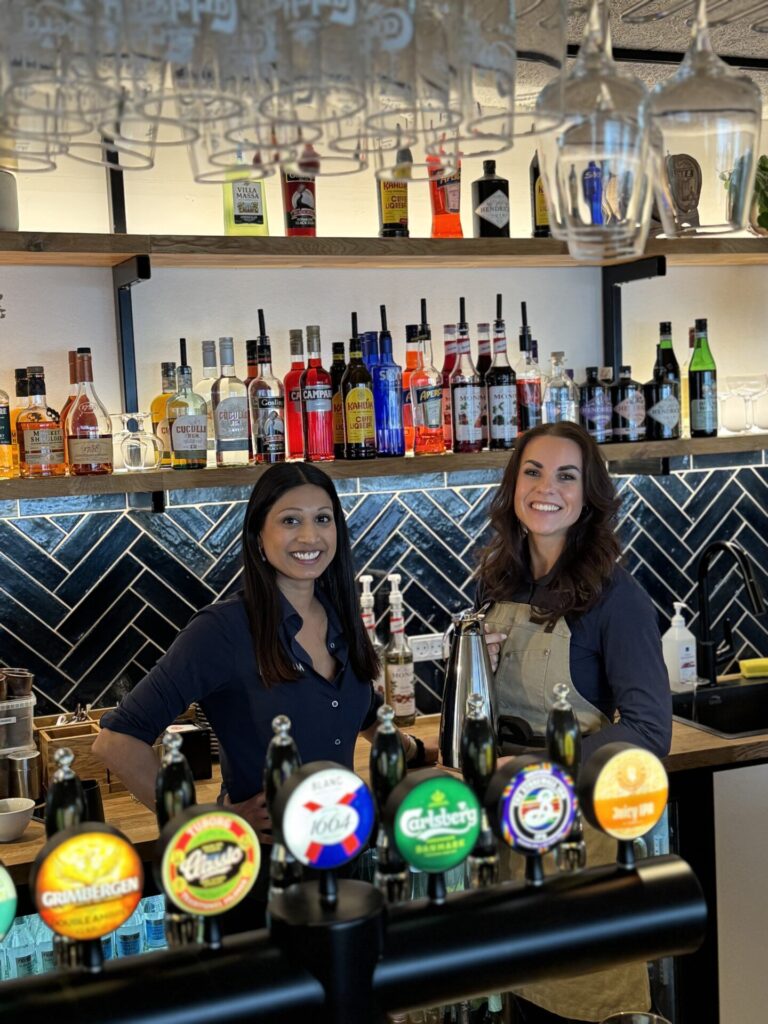 De tre søskende og deres partnere har forskellige funktioner i Restaurant Havrum – her står Christina Hoffmann Lauridsen (th) i baren sammen med Amanda Bejder (foto privat)