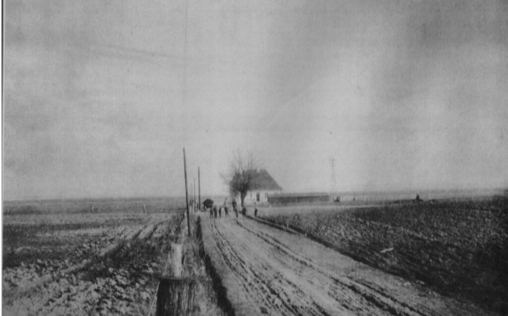 Nedenfor ses Sanatorievej fra starten i 1912 – en jordvej – og sanatoriets første bygning på grunden, næsten uden beplantning.