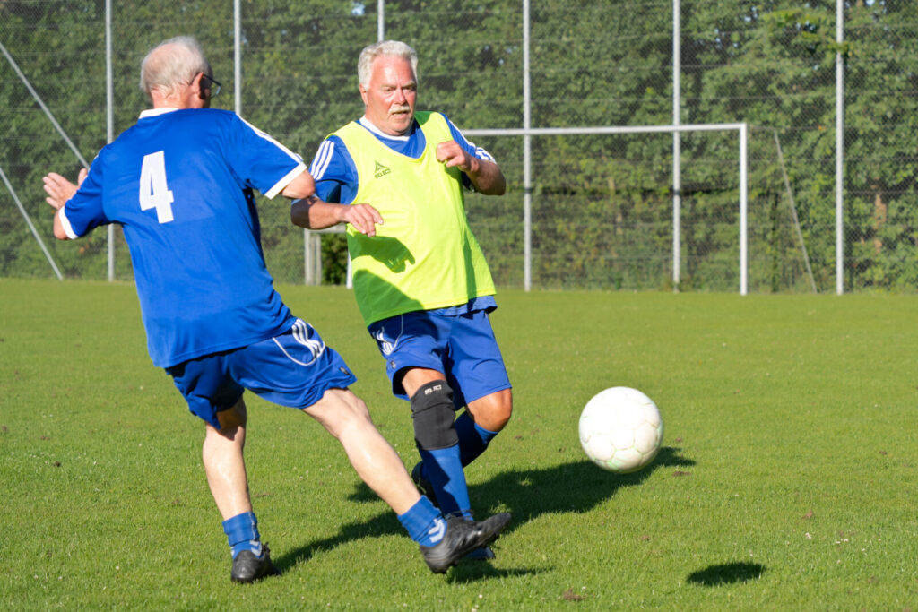 Aage Nielsen med nummer 4 og holdleder Hans Handberg kæmper om bolden.