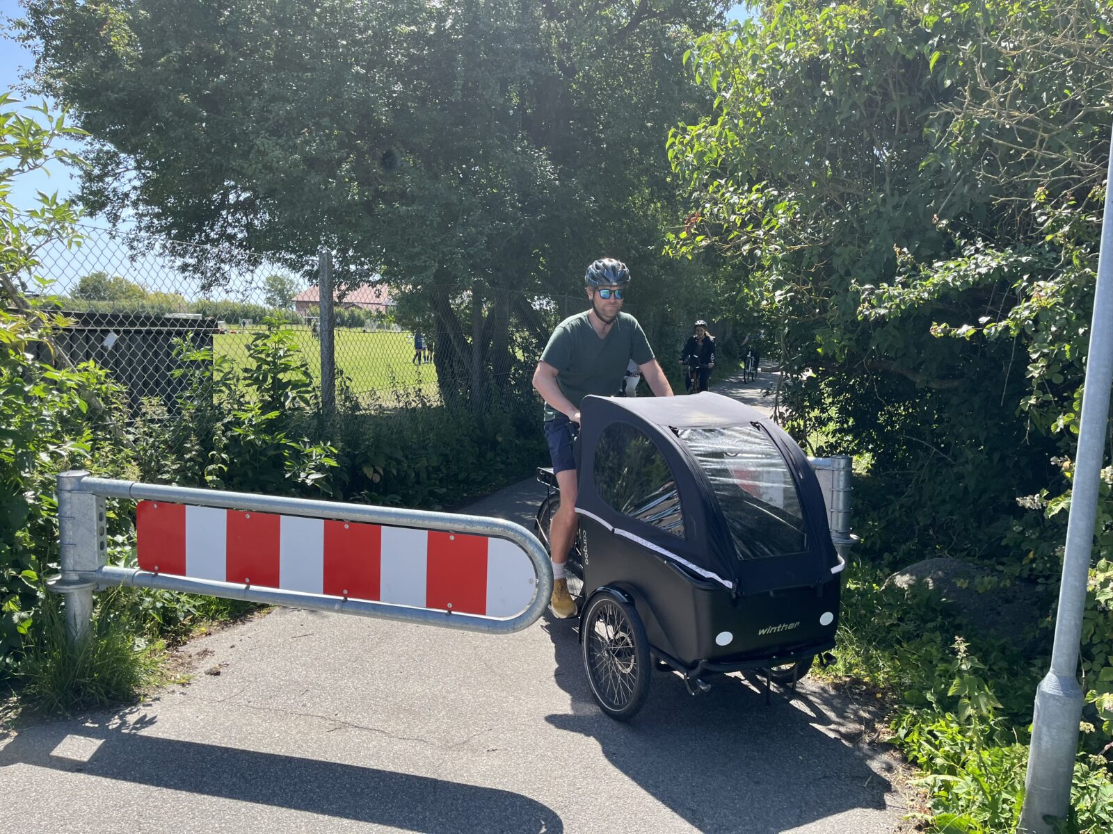 Projektleder Kim Andersen kører på ladcykel, hvor det mange steder er svært at passere snævre bomme. Her ved Fyrrevænget er det lige akkurat muligt.
