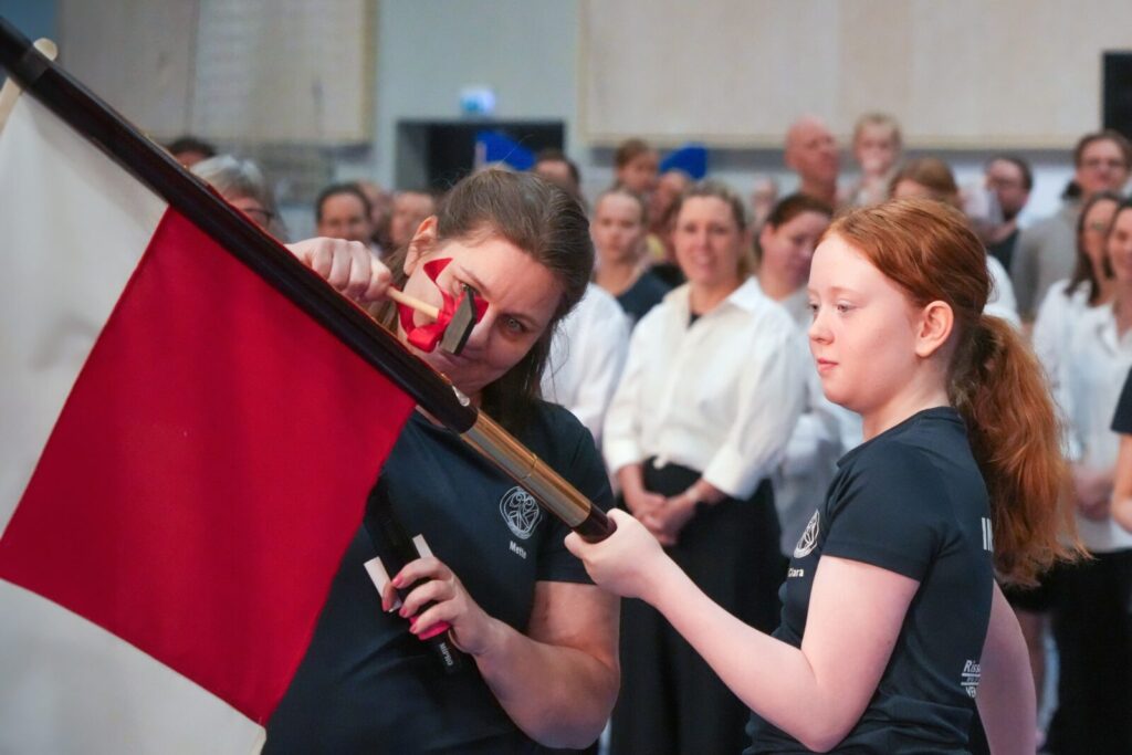 Den nye juniorfane får sin sølvplaquette sat fast.