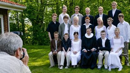 Erik med tilbagestrøget hår og en flok konfirmander i 2004. 